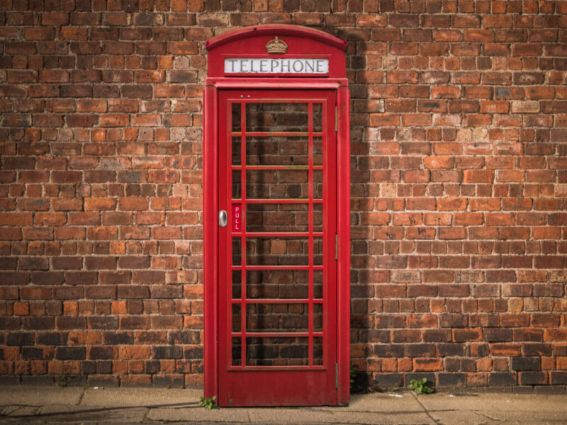British Phone Box Against Red Brick Wall